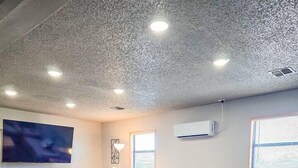 A modern living room with a grey sofa, a wooden coffee table, a flat-screen TV, and recessed ceiling lighting. - Angler Hideaway | Belle Starr Marina | Pool | Fish (Checotah)
