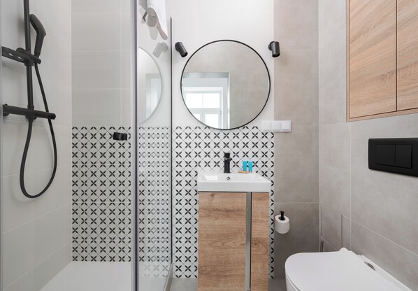 Enjoy a functional and stylish bathroom with a glass shower, sink, and toilet.