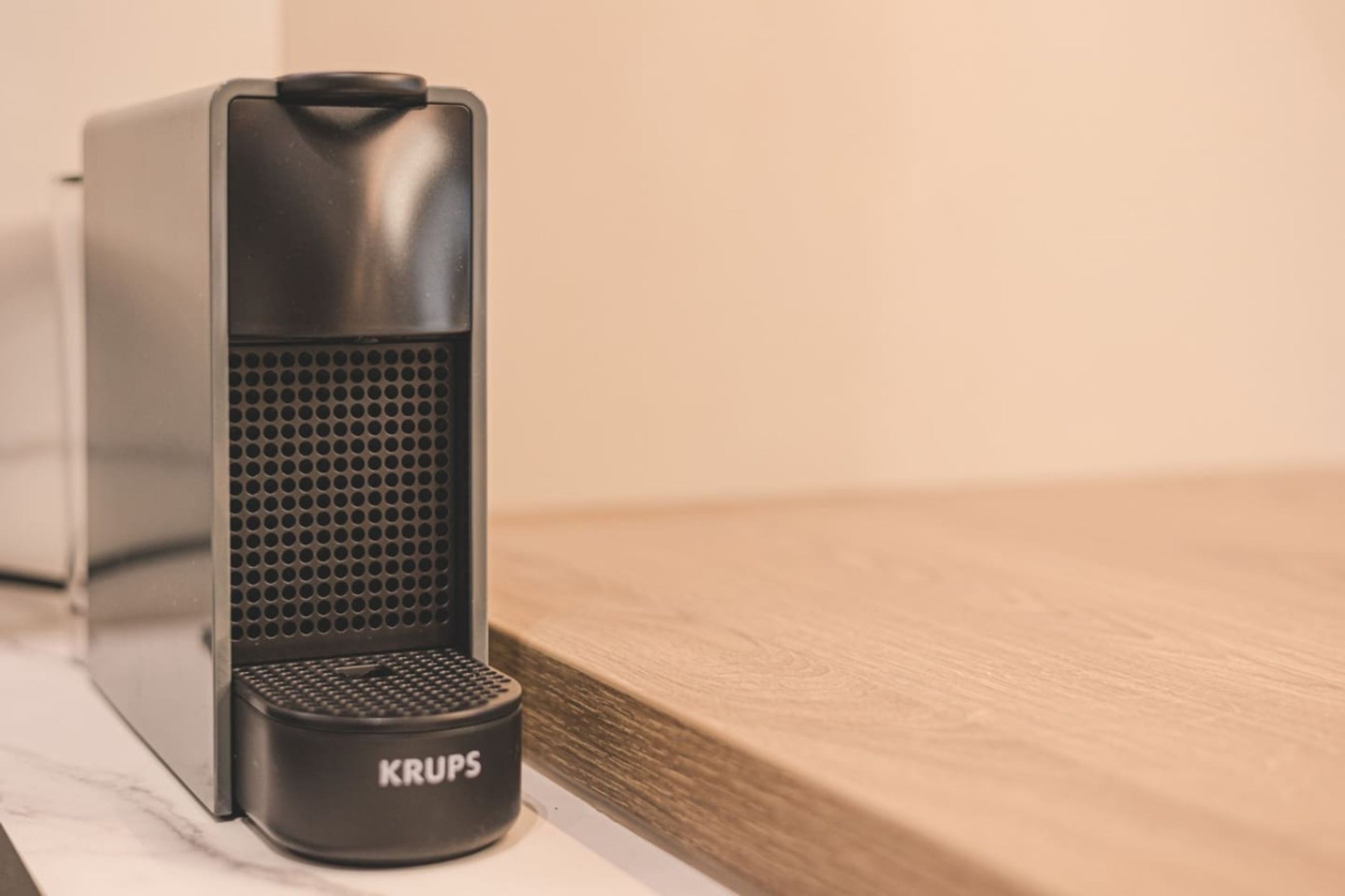 A black Krups electric kettle on a white countertop.