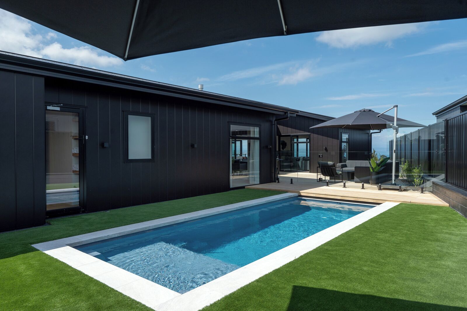 Ein modernes Haus mit Swimmingpool, Terrasse und Meerblick.