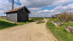 A gravel path leading to a rustic wooden building with a tiled roof. - Air-conditioned Zen Studio Near the Beaches, Quiet and Comfortable (Gujan-Mestras)
