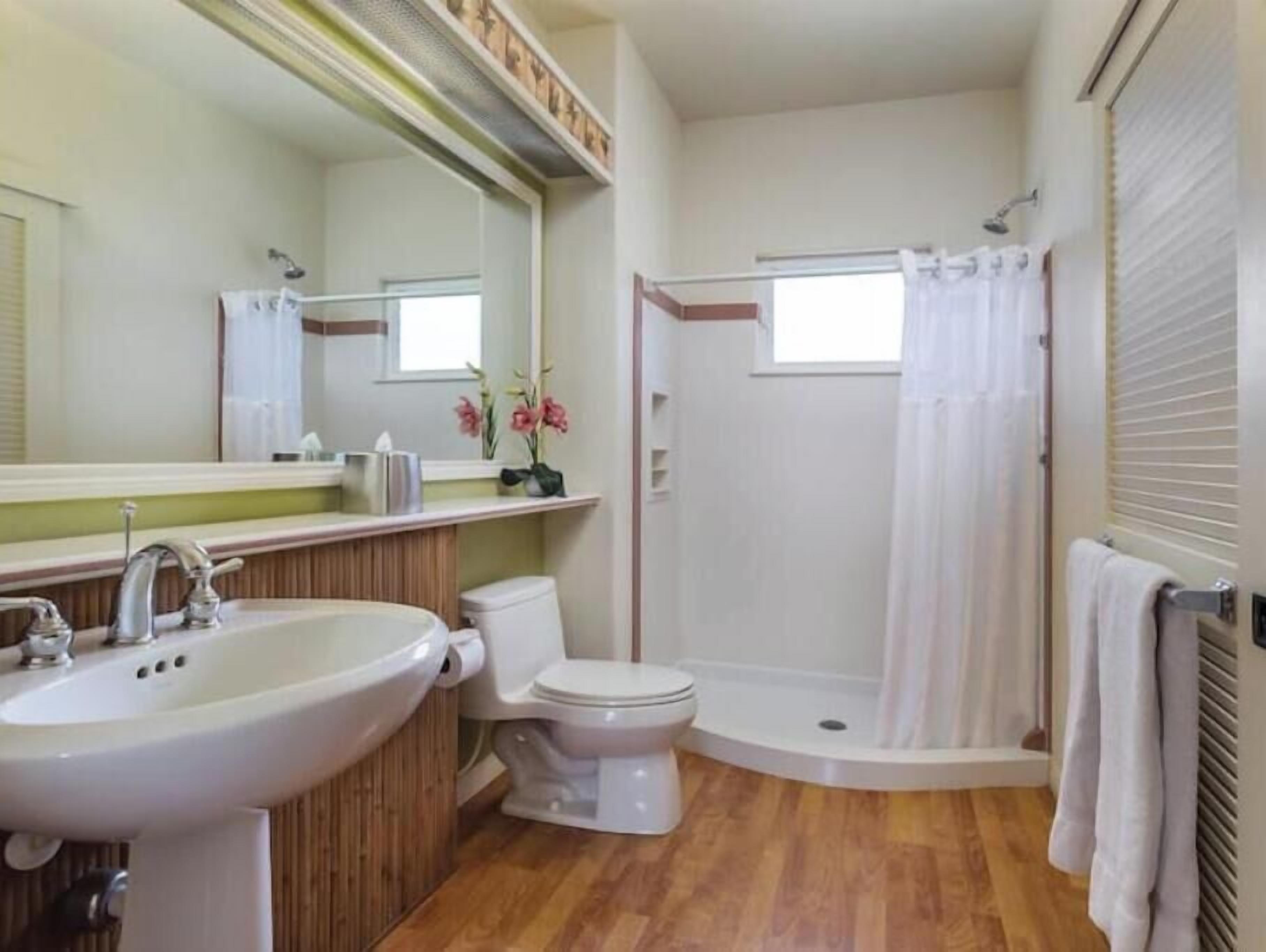 A bathroom with a sink, toilet, and shower.