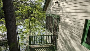 A wooden cabin with a balcony overlooking a forested area. - Hawthorne Cottages Edgewater (Raymond)