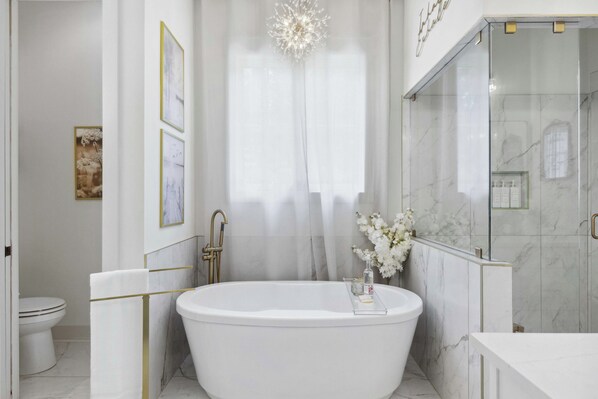 A modern bathroom with a freestanding bathtub, a glass shower enclosure, and marble walls. - Tim Ford Haven (Estill Springs)