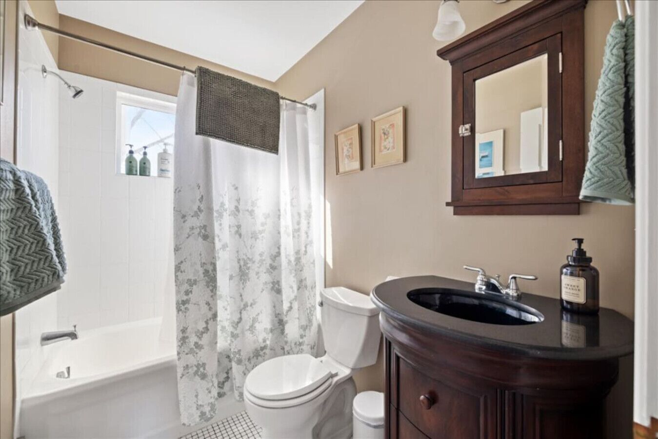 Un baño con bañera, inodoro y tocador con espejo.