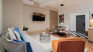 Una sala de estar moderna con un sofá, una mesa de centro y un televisor montado en la pared.