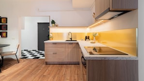 Una cocina moderna con armarios de madera, encimera de mármol y grifo negro.