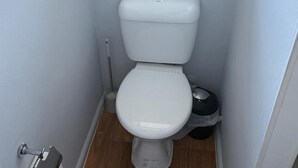 A compact bathroom with a white toilet, a bidet, and a small trash bin. - 301 Bealey Ave Motel (Christchurch)