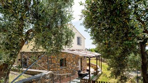 A stone house with a covered patio and a wooden fence. - Olive Lodge by Interhome (Civezza)