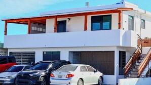 A modern two-story building with a garage, a staircase, and a covered outdoor area. - Private Colonial w/ Modern twist 2 BR w/Pkng & Laundry (Carolina)