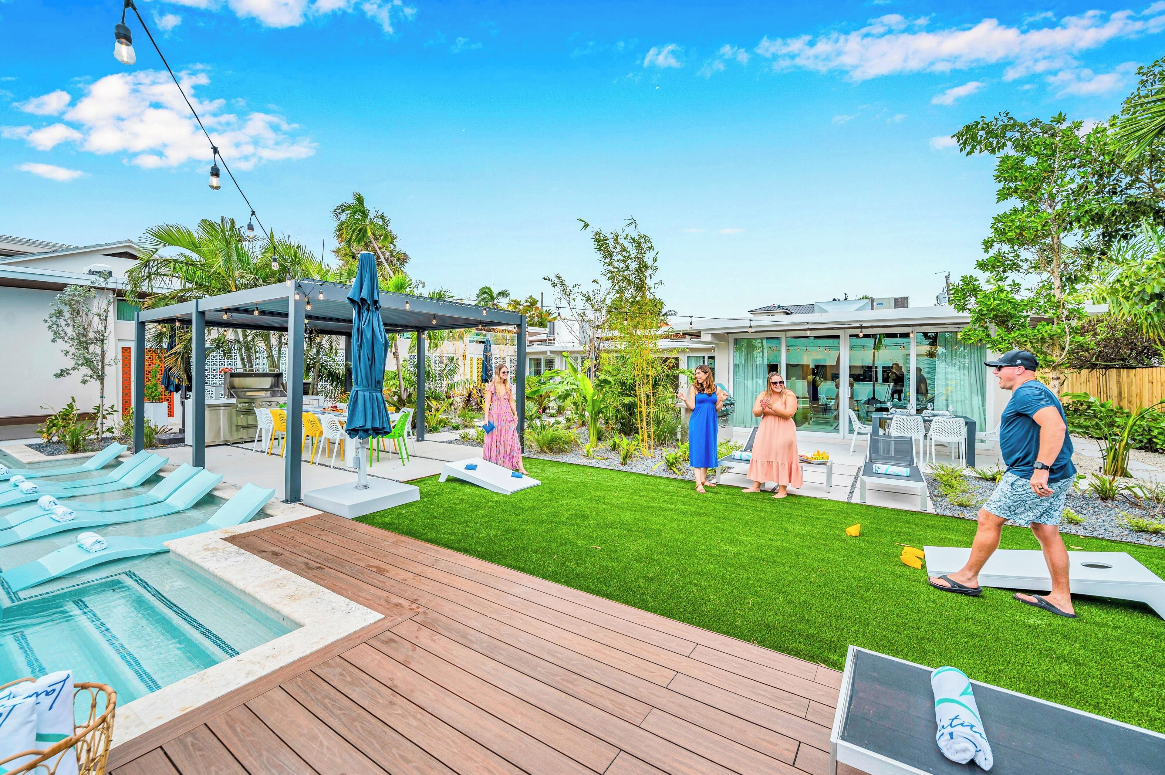 Un jardin avec une piscine, une pergola et un espace aménagé pour s’asseoir.
