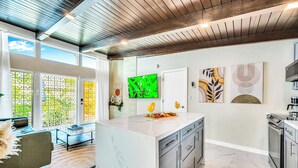Una cocina moderna con una isla de mármol, electrodomésticos de acero inoxidable y obras de arte en las paredes.