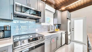 Una cocina moderna con electrodomésticos de acero inoxidable, horno empotrado y microondas.