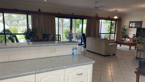 A spacious living area with a kitchen counter, a sofa, and a television. - Private mooring with access to the main river, just 75 metres away. (Renmark)