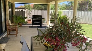 A covered patio with a grill, seating area, and potted plants. - Private mooring with access to the main river, just 75 metres away. (Renmark)