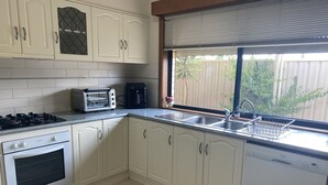 A kitchen with white cabinets, a gas stove, a toaster, and a dishwasher. - Private mooring with access to the main river, just 75 metres away. (Renmark)