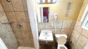 Ein Badezimmer mit Dusche, Waschbecken und Toilette.