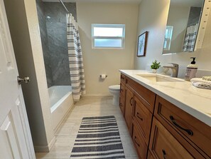 Enjoy a refreshing shower in the bathroom with a separate shower area and a sink with multiple drawers.