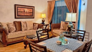 Una sala de estar acogedora con un sofá, una mesa de comedor y un cuadro en la pared.