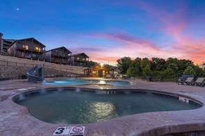 A resort with a pool area, a slide, and multiple buildings with balconies.