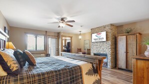 Een slaapkamer met een bed, een plafondventilator, een stenen muur, een houten kast en een bordje voor Table Rock Resorts.