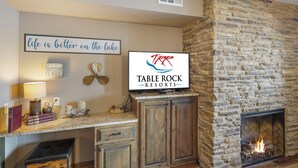 A stone fireplace with a TV mounted above it displaying 'Table Rock Resorts'.