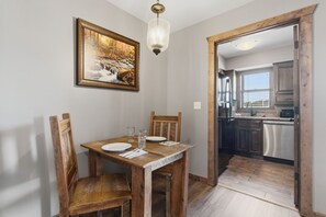 Ein Essbereich mit Holztisch, Stühlen und einem Bild an der Wand.