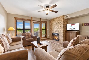 Un salon doté d’une cheminée, d’un ventilateur de plafond et d’un téléviseur affichant le logo de Table Rock Resorts.