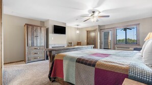 A bedroom with a large bed, a ceiling fan, a TV, and a window with blinds. - Studio Lake Condo, Resort Perks, Golf and Ticket Discounts (Branson)