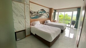 Ein Hotelzimmer mit zwei Betten, einer Marmorwand, einem Gemälde und einem Balkon mit Blick.