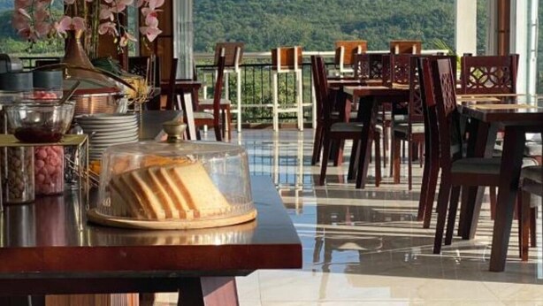 Ein Essbereich mit Tischen und Stühlen, einem Buffet und Blick auf einen Berg.