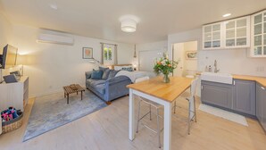 A modern apartment with a living room, a dining area, and a kitchen.