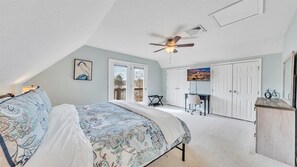 Cozy retreat with a sloped ceiling, featuring a comfortable bed and two windows.