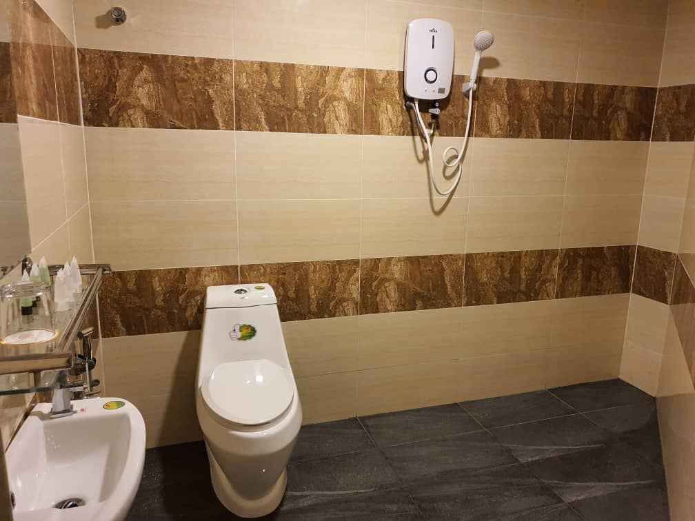 Ein Badezimmer mit Toilette, Bidet und einer an der Wand befestigten Handbrause.