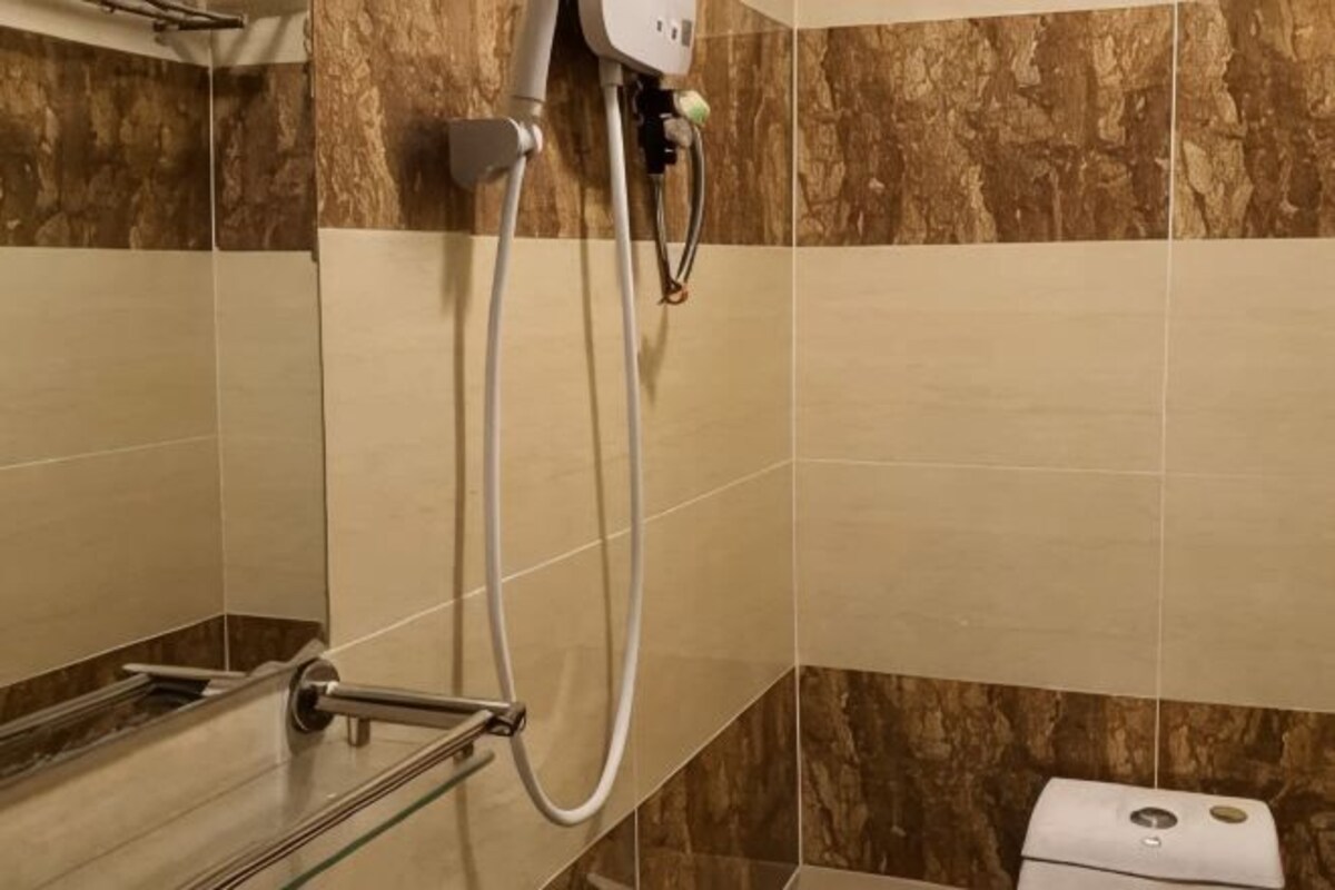 Un baño con ducha, toallero y retrete.