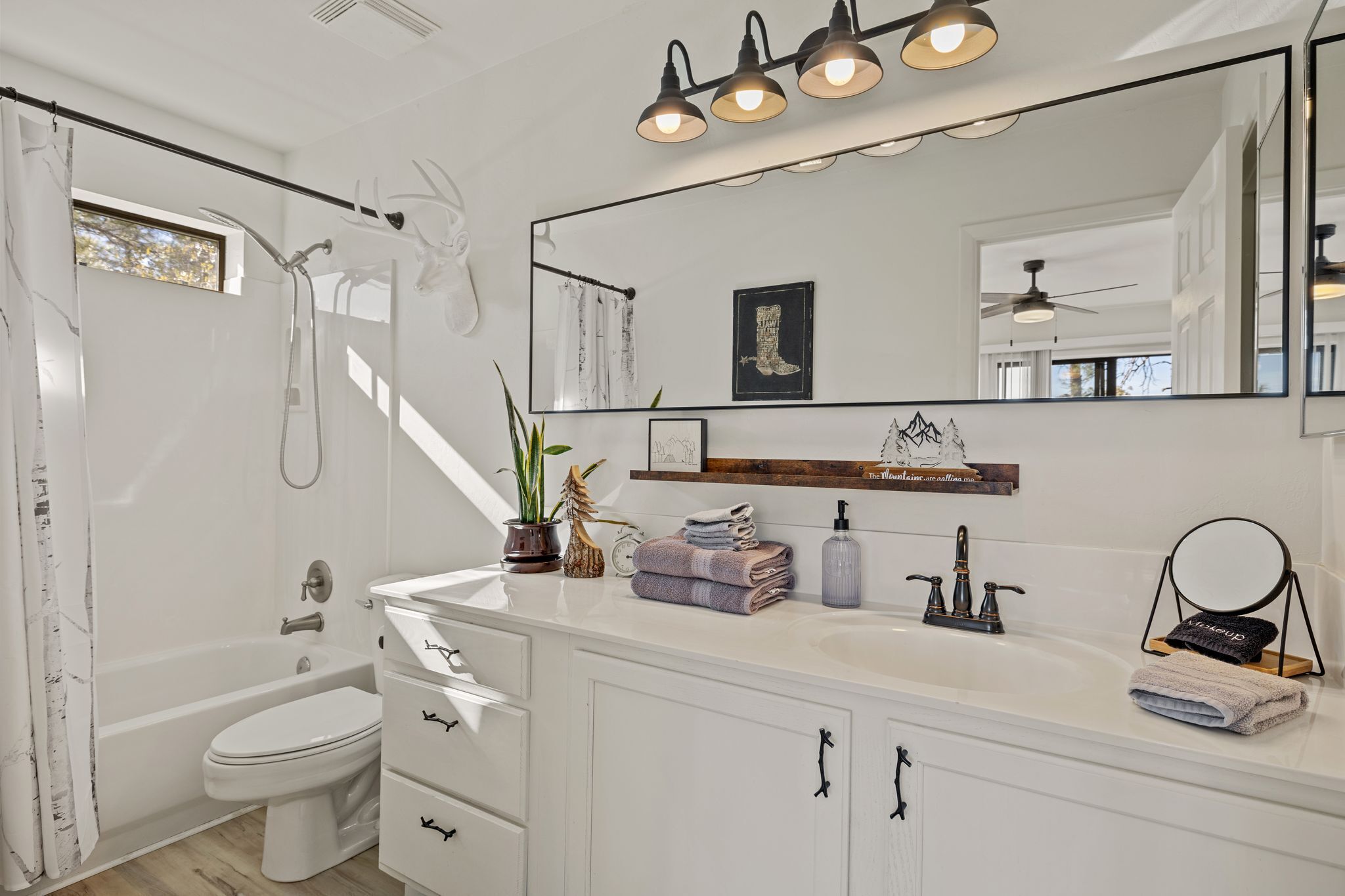 A modern bathroom with a bathtub, toilet, and vanity.