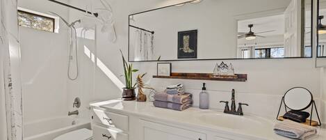 A modern bathroom with a bathtub, toilet, and vanity.
