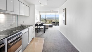 Une cuisine moderne avec un coin repas et un balcon offrant une vue sur la ville.