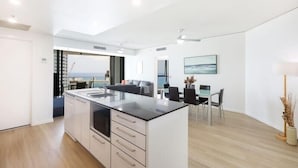 Une cuisine moderne dotée d’un îlot central, d’un coin repas offrant une vue agréable et d’un décor minimaliste.