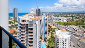 Un immeuble de grande hauteur doté de nombreux balcons et offrant une vue sur le paysage urbain de la côte.