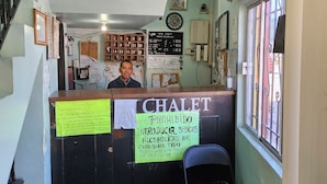 A hotel reception area with a sign prohibiting the introduction of alcoholic beverages. - Hotel Chalet (Matamoros)