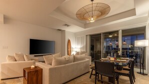 Un soggiorno moderno con un divano, un tavolino, una televisione e un'area da pranzo con tavolo e sedie.