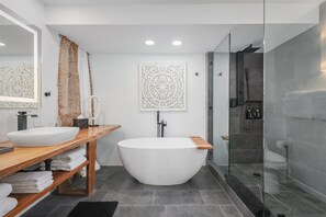A modern bathroom with a freestanding bathtub, two sinks, a large mirror, and a shower area. - Modern Boho Penthouse, Majestic Views, Hilton Pool 🏖️, 2BR+Bonus, Sleeps 6 (Waikoloa)