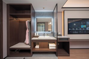 A modern bathroom with a vanity, a mirror, and a built-in shower.