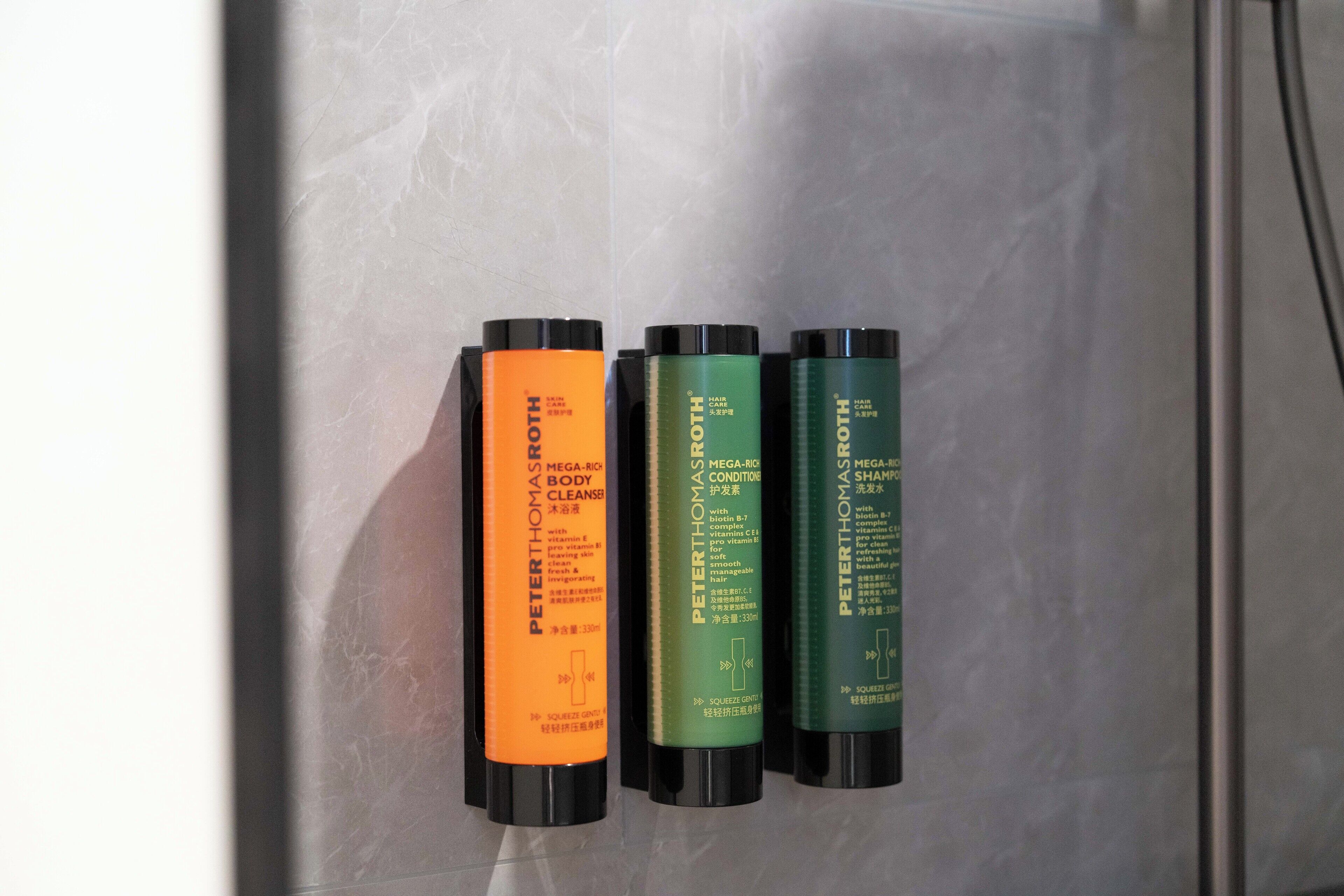 Drei Flaschen Körperpflegeprodukte von Peter Thomas Roth an einer Badezimmerwand.