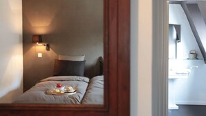 A bedroom with a bed, pillows, a bedside table with a lamp, and a tray with food. - Spacious, Luxurious, & Cozy Holiday Home - Le Dragon Limbourg (Limbourg)