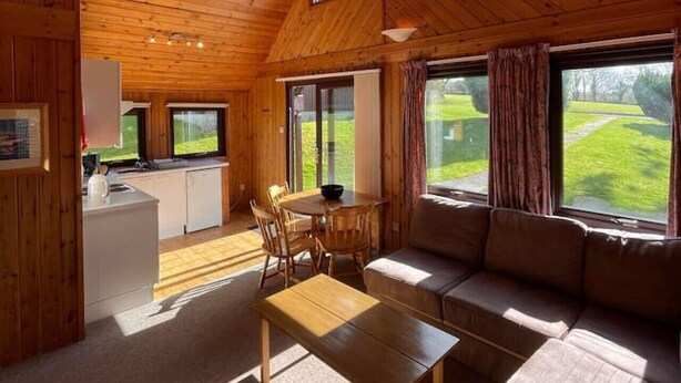 A wooden interior with a dining area, sofa, and large windows. - 3 Bedroom Lodge Lanteglos #21 (Lanteglos)