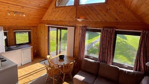A wooden interior with a dining area, sofa, and kitchen. - 3 Bedroom Lodge Lanteglos #21 (Lanteglos)