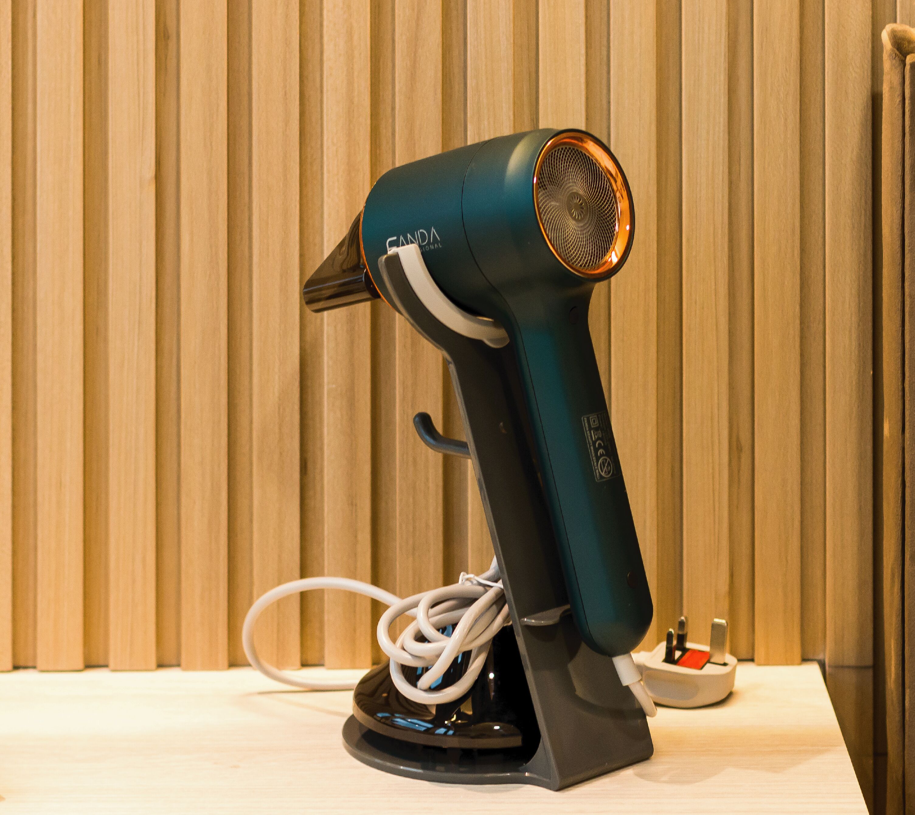 A hair dryer on a table with a wooden background.
