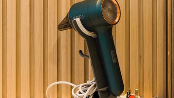 A hair dryer on a table with a wooden background.